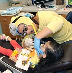A Photo of a Dentist Aiding a Dental Treatment to a Child Patient